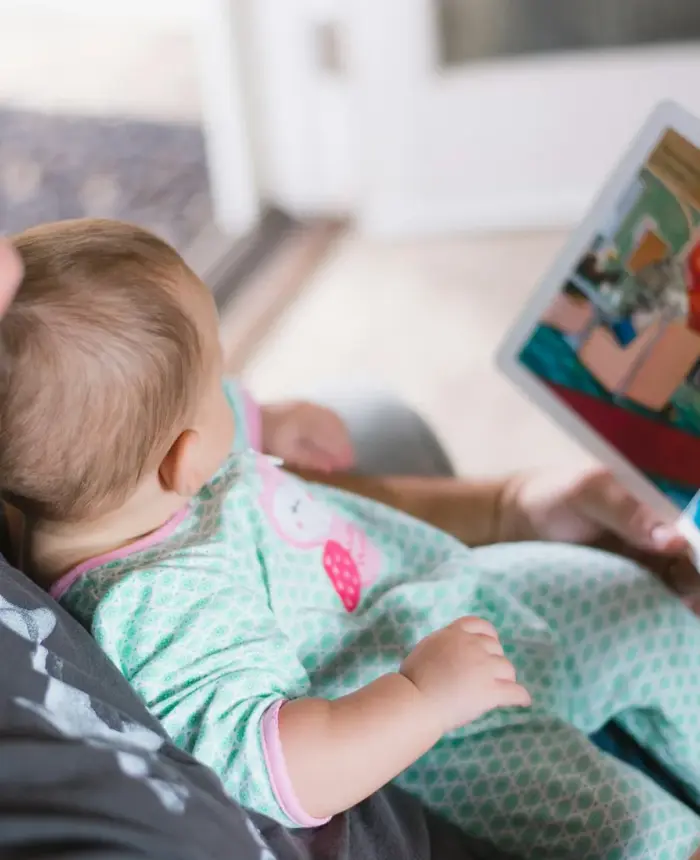 Un padre leyendo un libro ilustrado con su bebé en el regazo
